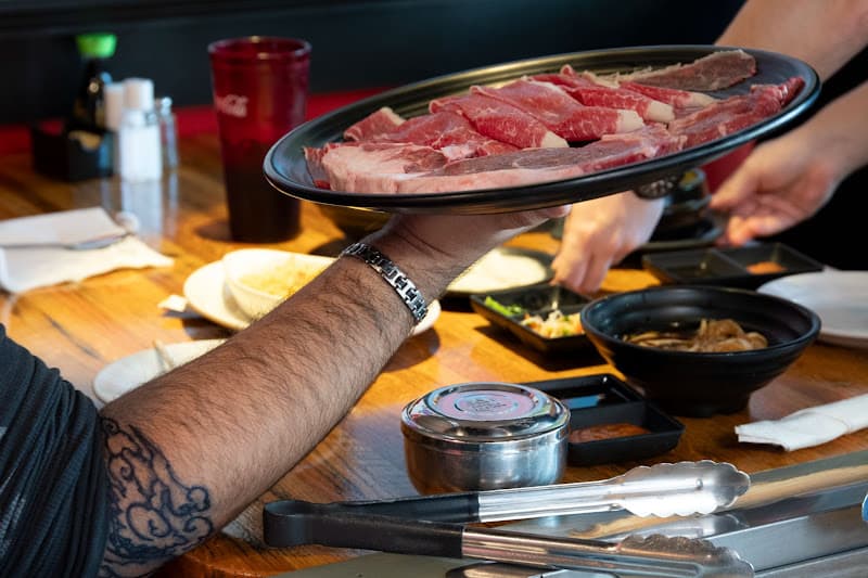 Matjoa House server presenting a tray of raw beef tableside